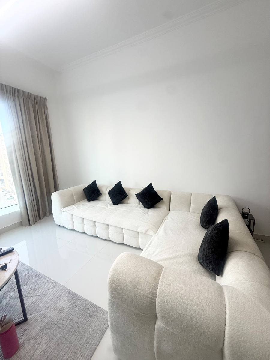 A white L shaped sofa in a Dubai apartment, listed on Loop