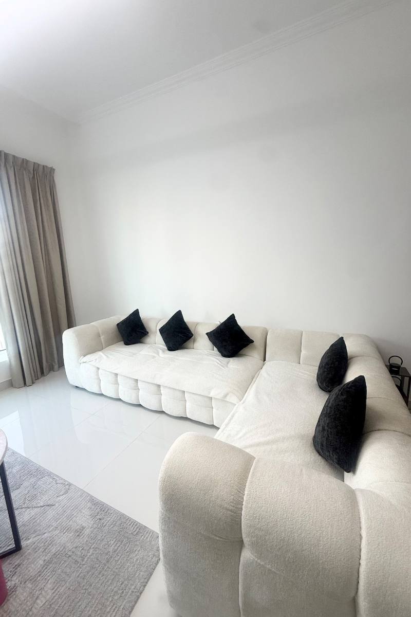A white L shaped sofa in a Dubai apartment, listed on Loop