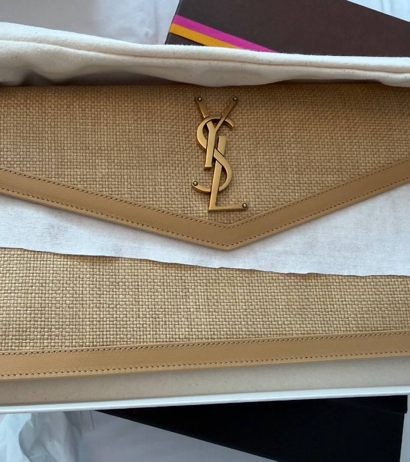 A woven designer pouch on tissue paper, listed on Loop